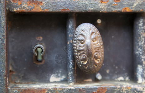 生锈的金属门上金属门把手和钥匙孔的特写图片