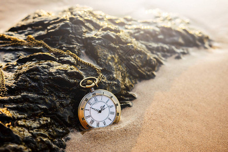 黄金沙滩在日出或夏日落时金沙滩的旧式袖手表背景图片