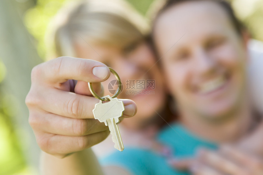 幸福的情侣在门外拿着空房钥匙里面有钥匙上