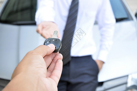 向另一个男人提供汽车钥匙的手汽车销售和图片