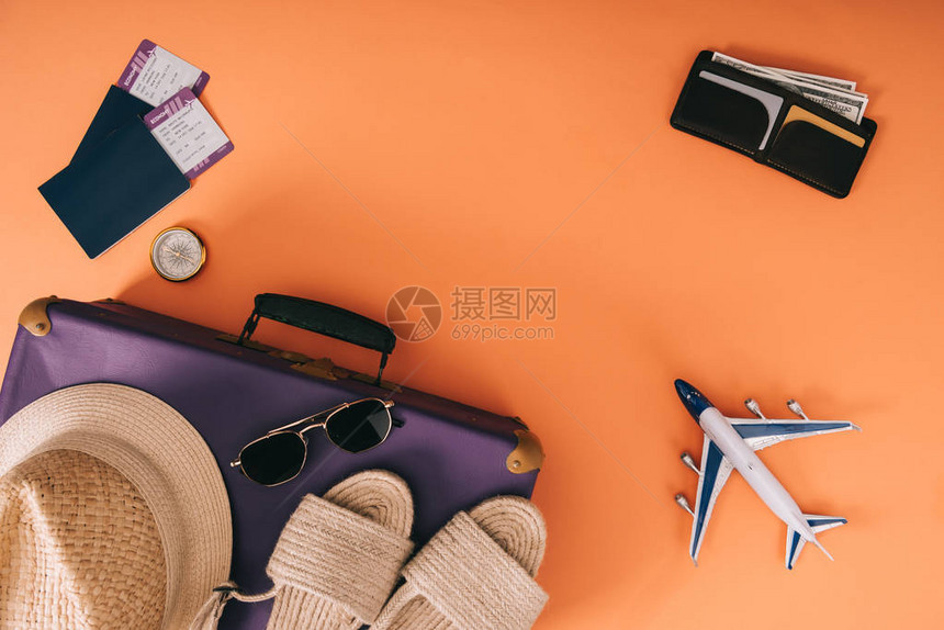 旅行袋飞机型号钱包和带有橙色背景机票的护照上夏季附图片