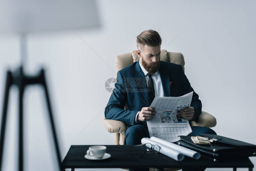 集中的商人在办公室用灰色阅读图片