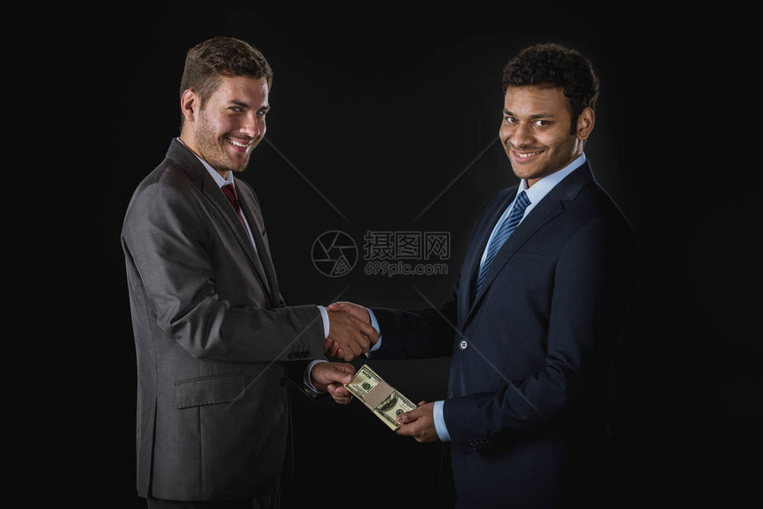 商人给钱和贿赂被黑人孤立的商业伙伴商图片