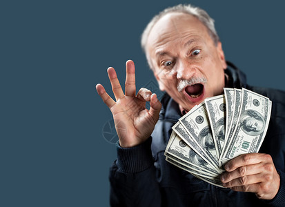 快乐的老人展示钱的风扇图片