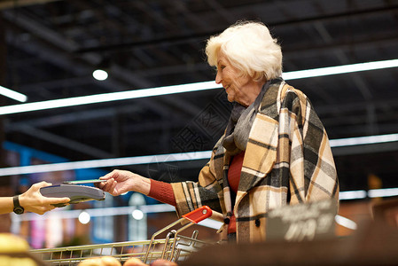现代高龄女通过智能手机支付NFC付款图片