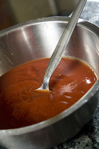 用不锈钢勺子把番茄泥放在不锈钢碗里图片