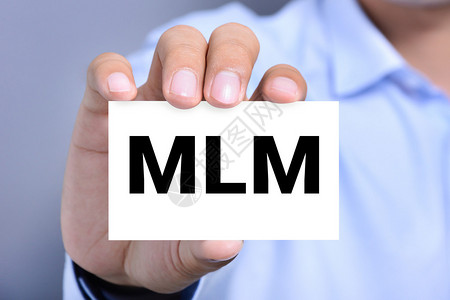 男子手持的卡片上的MLM字母背景图片
