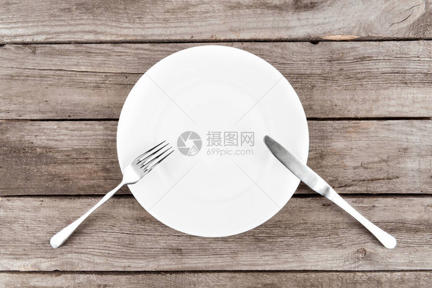 木桌上排列的空盘子叉子和刀子的顶视图图片