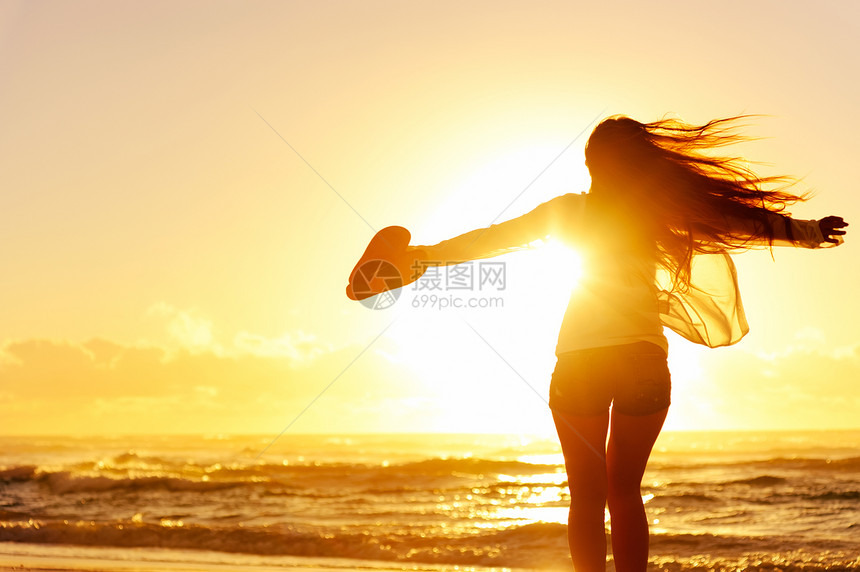 无忧虑的女人在夕阳下在沙滩上跳舞假期活力图片
