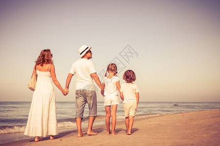幸福的家庭白天在沙滩上走来去友图片