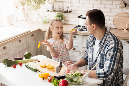 快乐的小女孩和她爸在家做饭图片