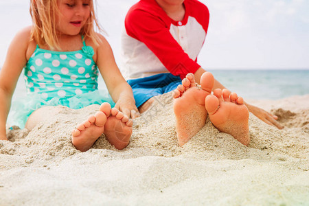 男孩女在海滩上玩沙图片