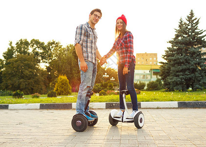 年轻夫妇骑气垫板电动滑板车个人生态交通工具陀螺滑板车智能平衡轮图片
