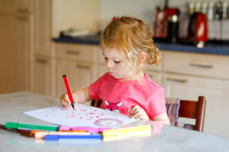 可爱的小蹒跚学步的女孩在家里用彩色铅笔画可爱的健康快乐的孩子使用毡尖笔学习绘画活跃的孩子在室内或托背景图片