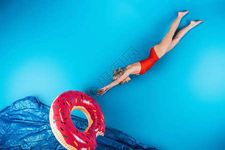 女孩游泳环潜水在想象中的海中潜入蓝图片