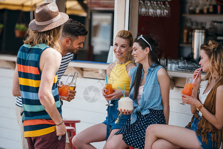 快乐的青年男女在沙滩酒吧聊图片