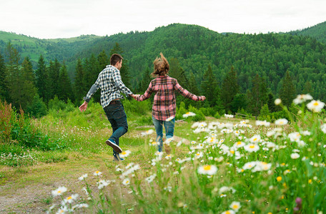 年轻情侣在山上漫步一对快乐的情侣回到图片