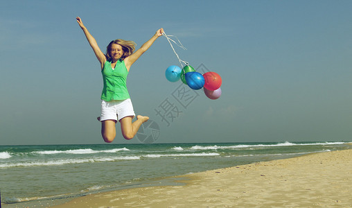 海滩上有气球的漂亮女孩图片
