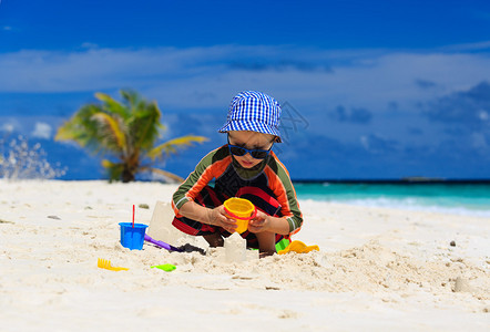 可爱的小男孩在沙滩上玩耍图片