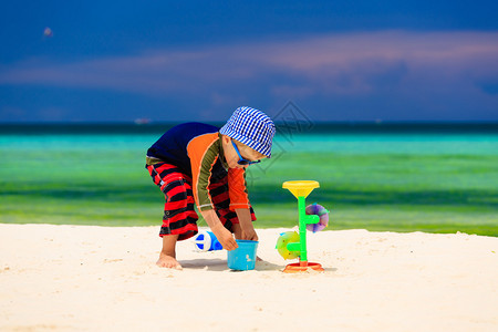 小男孩在热带沙滩上玩水图片