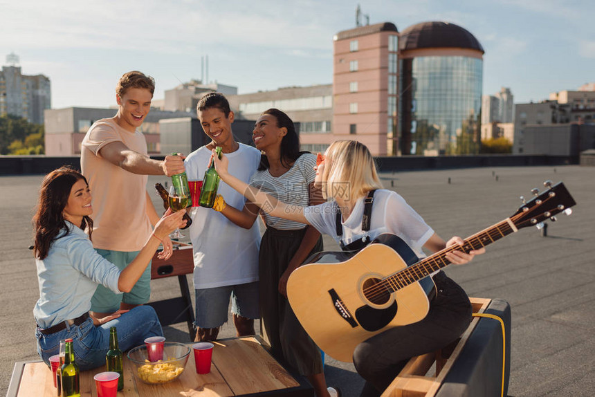 一群快乐的年轻朋友在屋顶上开派对啤图片