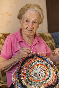 编织钩针地毯的老妇人图片