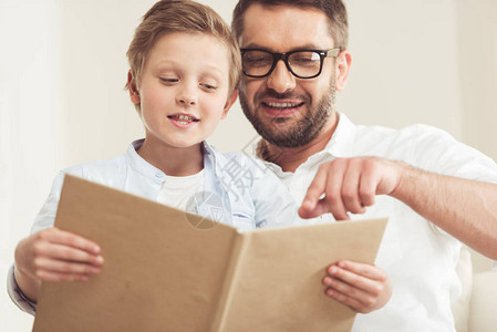 小儿子和爸在家一起看书的背景图片