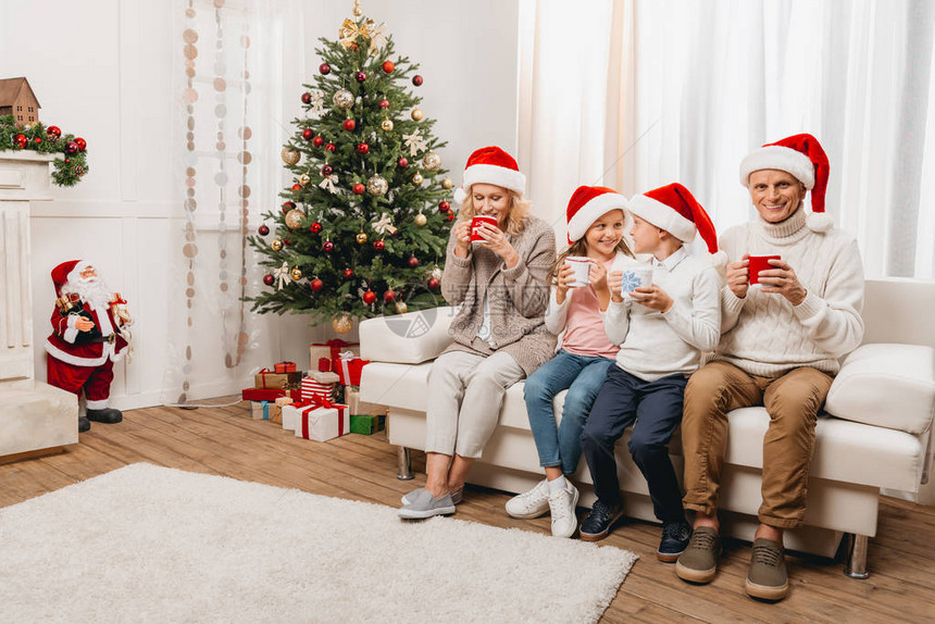 外祖父母和穿着圣塔帽的孩子在圣诞节图片