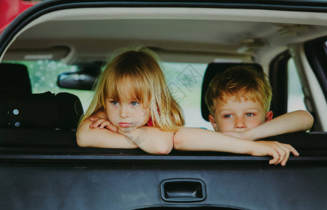 女孩和男孩在汽车中等待无聊的悲伤疲累难与图片