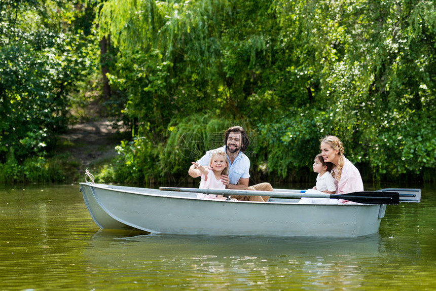 年轻家庭在公园河边的船上共渡图片