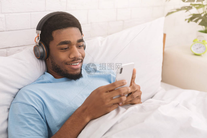 使用耳机听音乐或观看在线流传广播躺在床上复制空间的黑