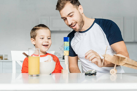 英俊的年轻父亲和儿子在家里厨房玩具图片