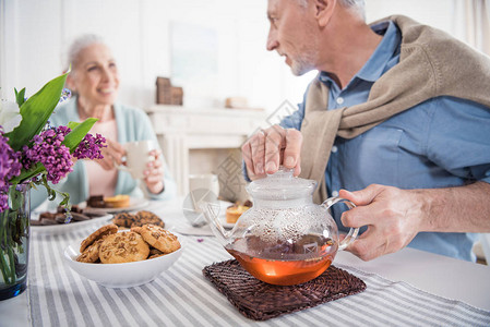 在家吃早餐时微笑的老年夫妇喝茶图片