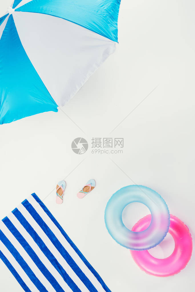 海滩雨伞条纹海滩毛巾翻滚式滑板和白色图片