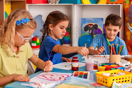 小学生在艺术学校课上画孩子在桌子上用颜料画幼儿园里的男孩和女孩绘画教育培养孩子的创造能力最好背景