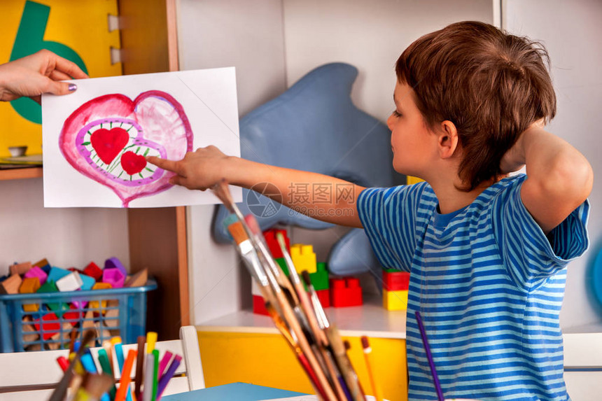 小学生男孩在艺术学校课上画心孩子在桌子上用颜料画母亲节假期儿童俱乐部的孩子工艺绘画教育培养孩图片