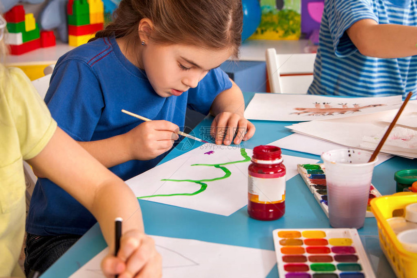 小学生在艺术学校课上画孩子在桌子上用颜料画幼儿园里的男孩和女孩绘画教育培养孩子的创造能力图片