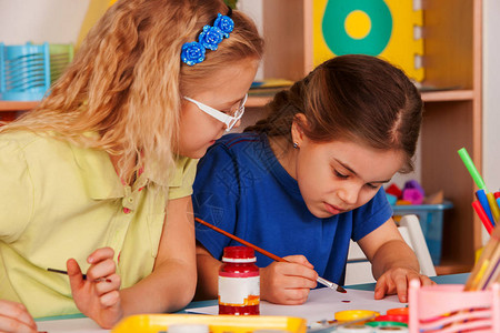 小学生女孩在艺术学校课上画孩子们在桌子上用颜料画孩子们被教导画工艺绘画教育培养孩背景图片