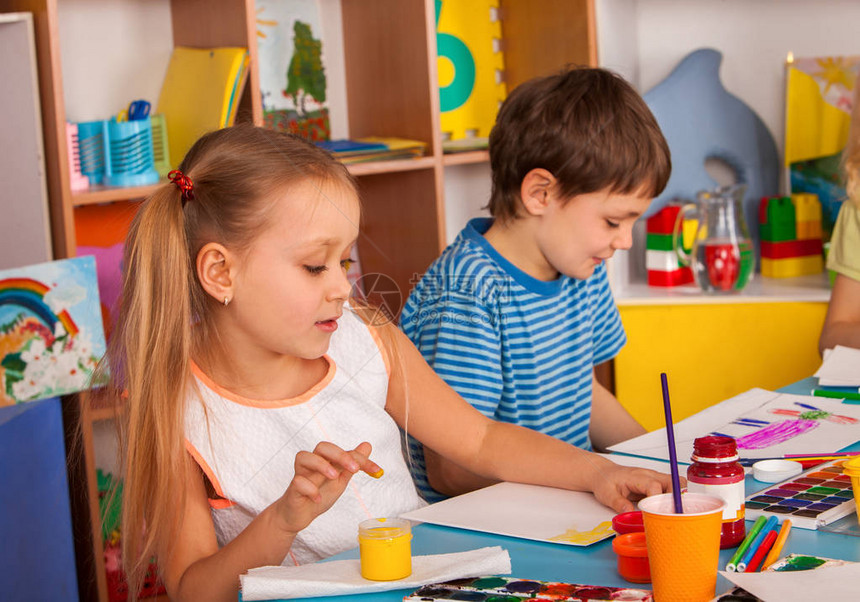 小学生女孩和男孩在艺术学校课上绘画孩子在桌子上用颜料画不寻常的绘画方式工艺绘画教育培养孩图片