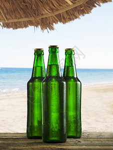 在沙滩酒吧桌边用水滴刷冰啤酒瓶热带岛的夏季图片