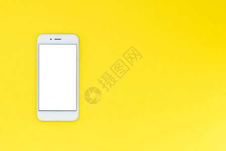 黄色背景的白色现代智能手机平坦的对现图片