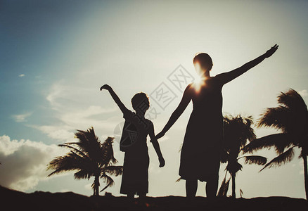 母亲和儿子在日落热带海图片