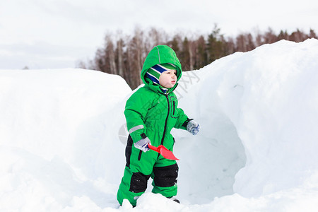 小男孩挖冬雪冬玩图片