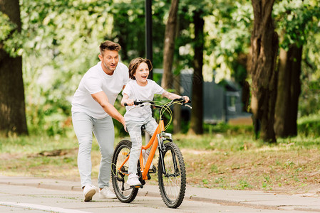 父亲在骑自行车而儿子骑自行图片
