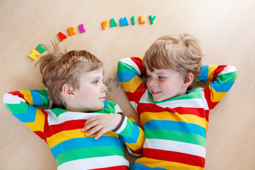两个兄弟姐妹男孩在室内一起玩乐孩子们穿着五颜六色的衬衫笑着图片