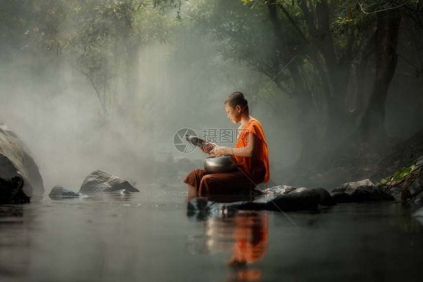 泰国小和尚坐在小溪或河流的森林中图片