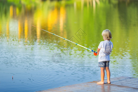 在码头钓鱼的小男孩图片