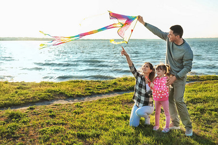 幸福的家庭在河边放风筝图片