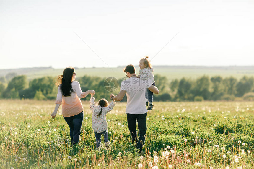 快乐的年轻家庭在绿色大自然中共度时光图片
