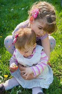 两个孩子坐在绿色草地上图片